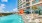 a pool with lounge chairs and a building in the background